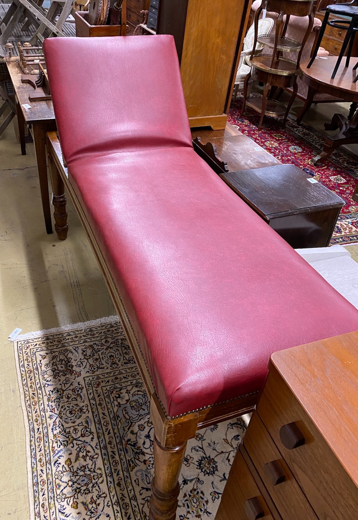 An Edwardian mahogany examination table by Ferris & Co. with red leatherette upholstery, length 186cm, height 63cm